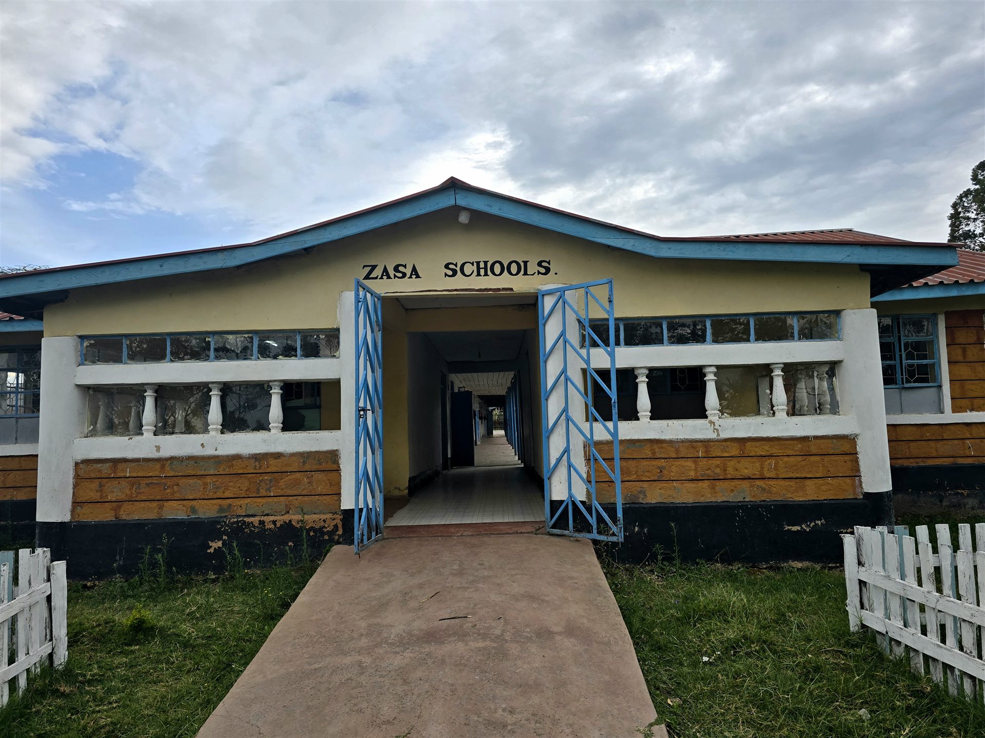 Open blue gates into the Zasa Schools classroom corridor